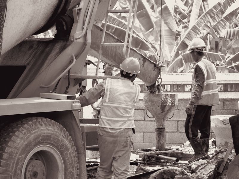 Concretagem com caminhão betoneira e equipe posicionando o funil de descarga.